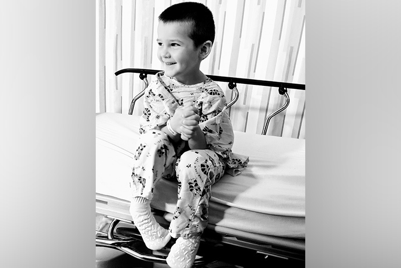 微笑的男孩坐在医院的轮床上