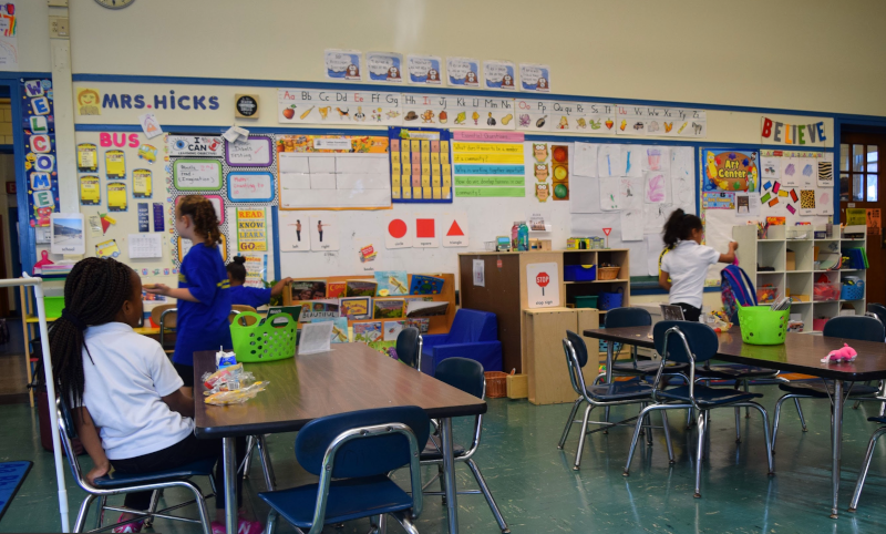 孩子们站在教室里的书桌上。